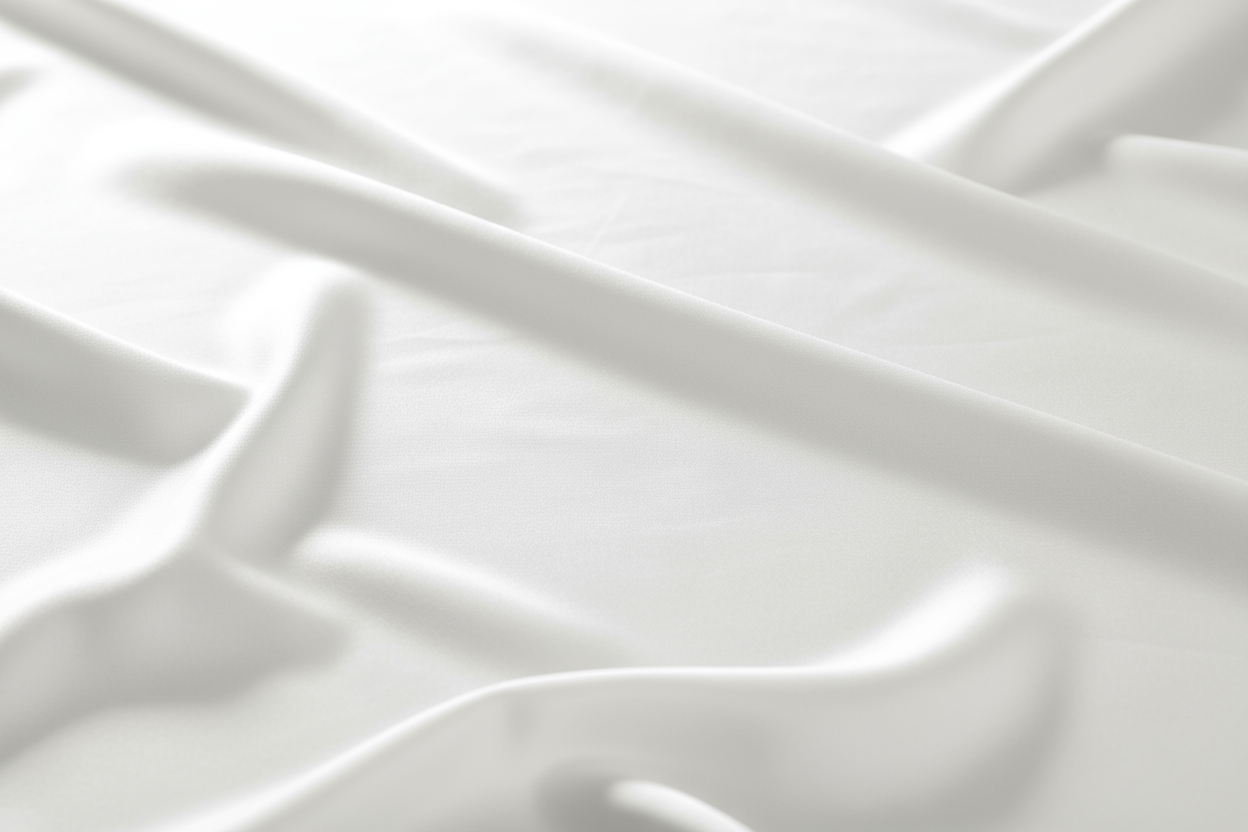 A clean white background with a subtle silk fabric texture — soft, elegant, and minimal. The surface should have gentle light reflections and smooth folds that suggest luxurious silk, without being distracting. 

Style: minimal, natural lighting, soft focus, high-resolution texture. 
Mood: calm, refined, premium. 
Colors: pure white with soft shadows and highlights. 
Composition: seamless background, no objects, no text, no people.
